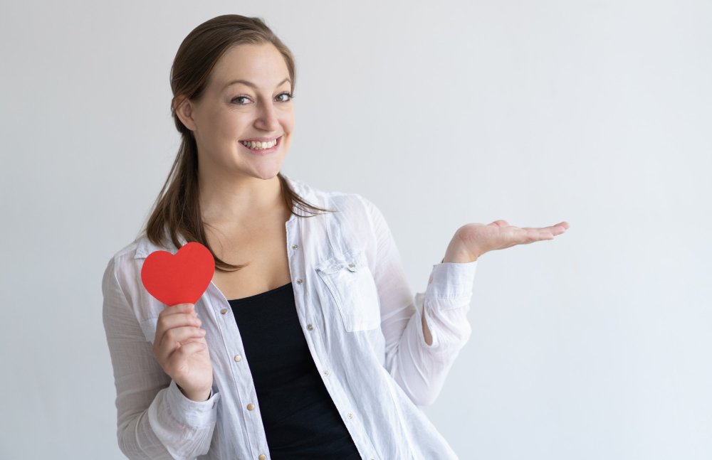 smiling-pretty-woman-holding-paper-heart-empty-space